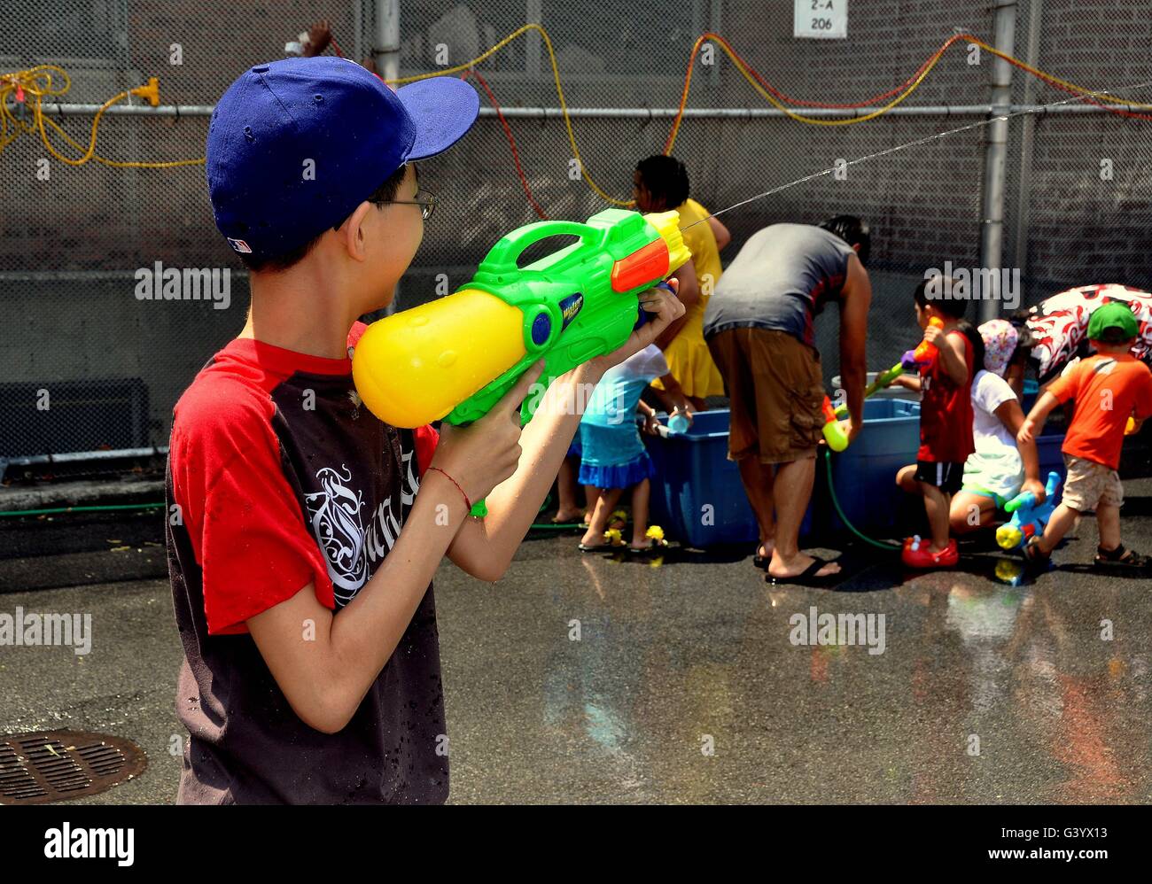 New York City: Bambini schizzi uno un altro con pistole di acqua è parte della grande divertimento a Thingyan birmano Festival di acqua Foto Stock