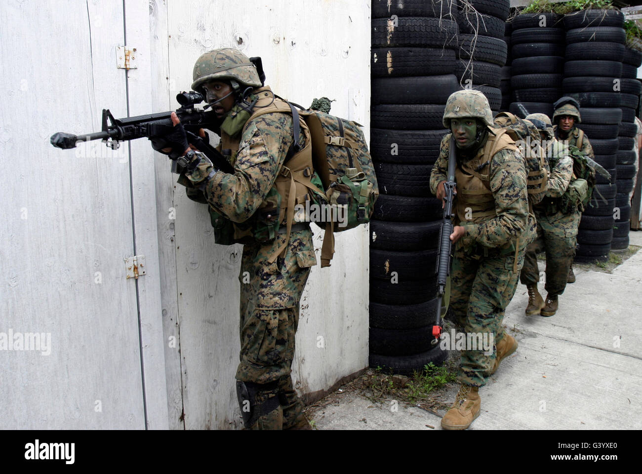 Marines chiaro di una casa in cerca di terroristi simulato durante un raid. Foto Stock