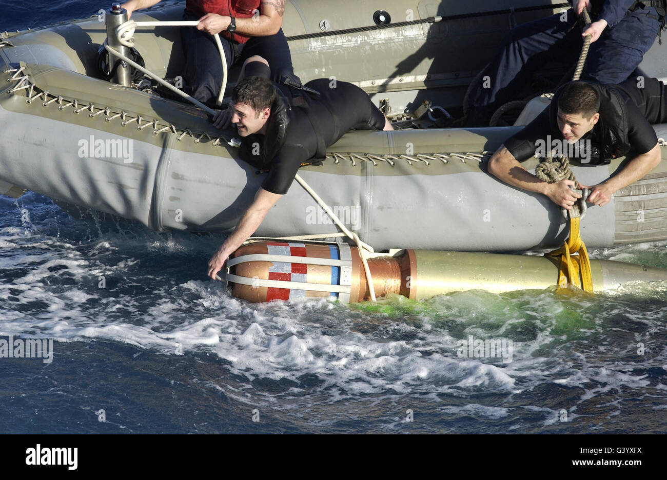 I nuotatori di salvataggio tirare un 480-pound possono dar luogo a rifusione siluro esercizio di ritorno alla nave. Foto Stock
