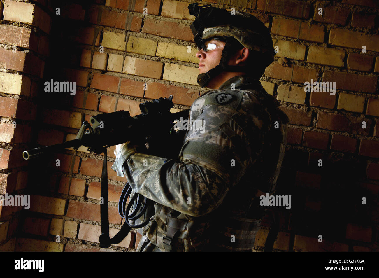 Stati Uniti Specialista dell'esercito esegue la scansione della zona per posizioni di Cecchino da una casa. Foto Stock