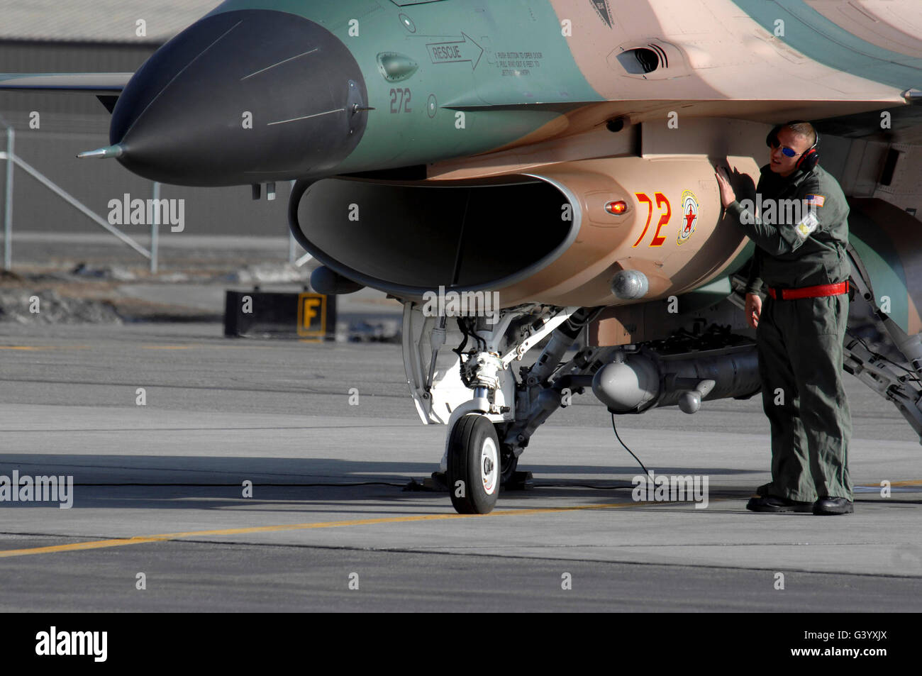 Un manutentore preps un nemico F-16 Fighting Falcon prima di una missione. Foto Stock