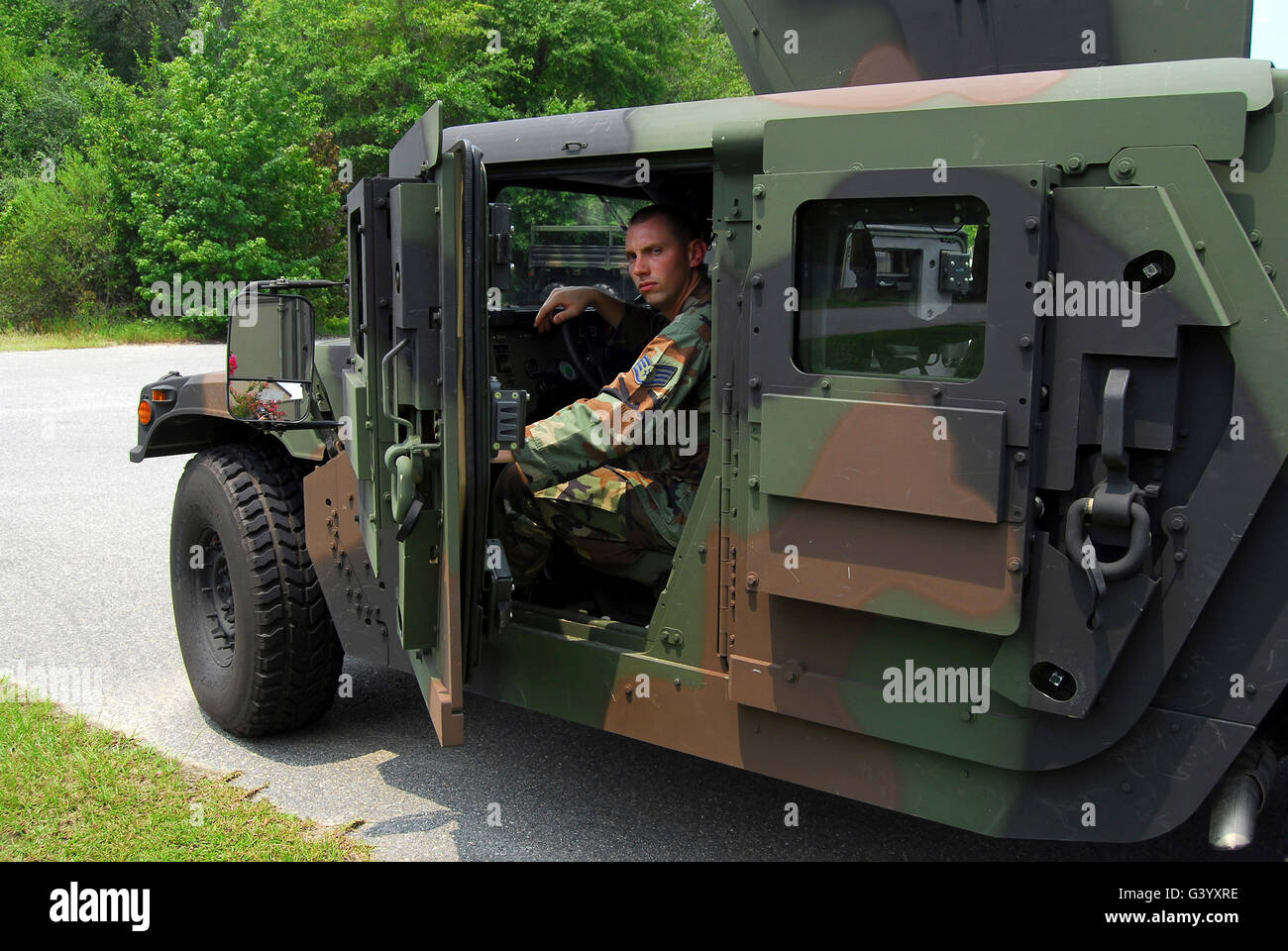 Soldato esegue un controllo di un Humvee blindato. Foto Stock