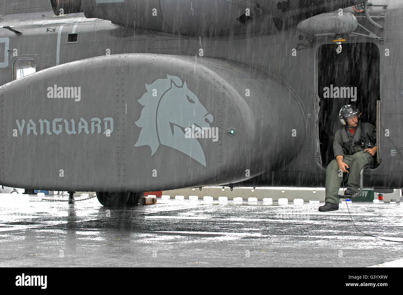 Stati Uniti Navy Aviation Warfare Systems Operator attende sotto la pioggia su un MH-53E mare Dragon. Foto Stock
