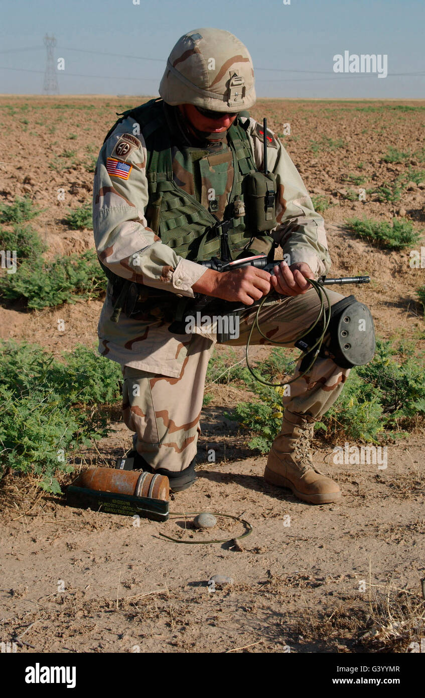 Un esercito sergente bracci a C-4 esplosivo attaccato ad un 115mm anti-serbatoio rotondo, Bayji, Iraq. Foto Stock