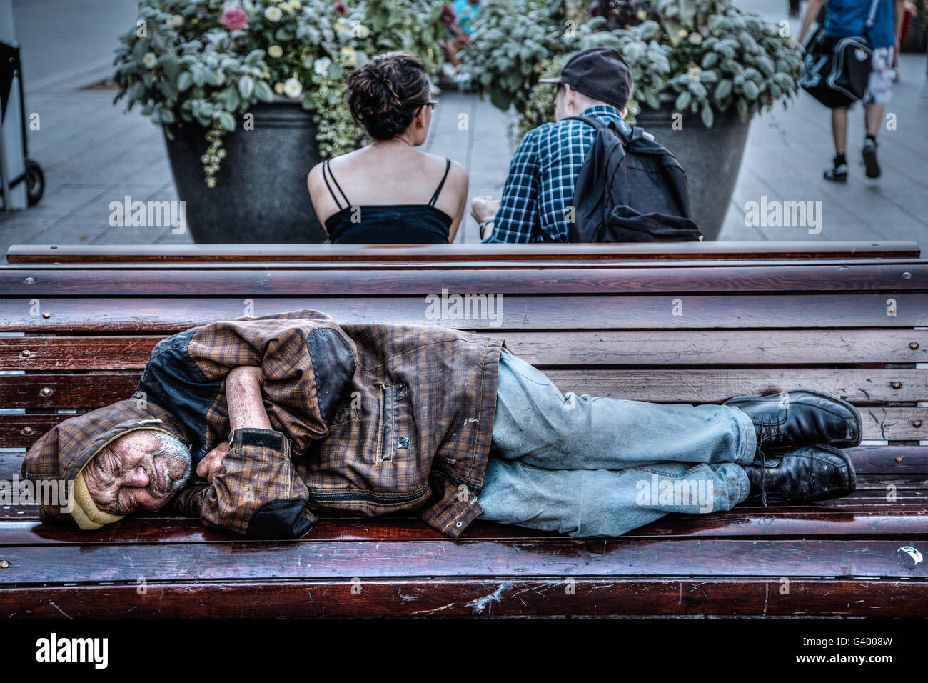 Montreal, Canada - 20 AGO 2012: un senzatetto uomo dorme su una panchina nel parco in Montreal, QC, Canada. Foto Stock