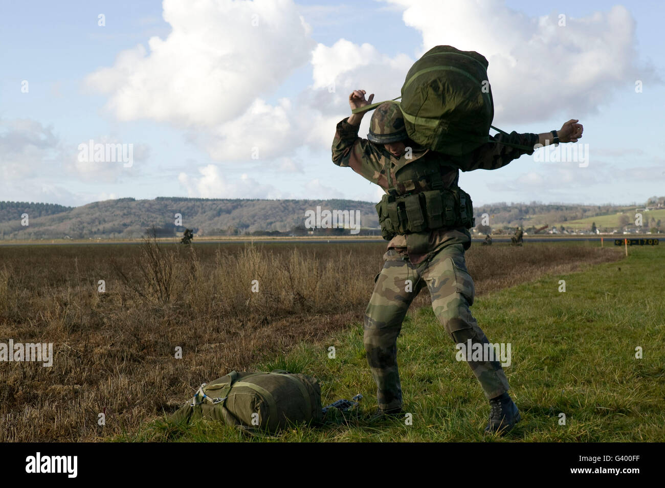 Un membro della Legione Straniera francese carichi il suo equipaggiamento sulla schiena dopo un salto sopra l'aeroporto di Tarbes, Francia, 2007 Foto Stock