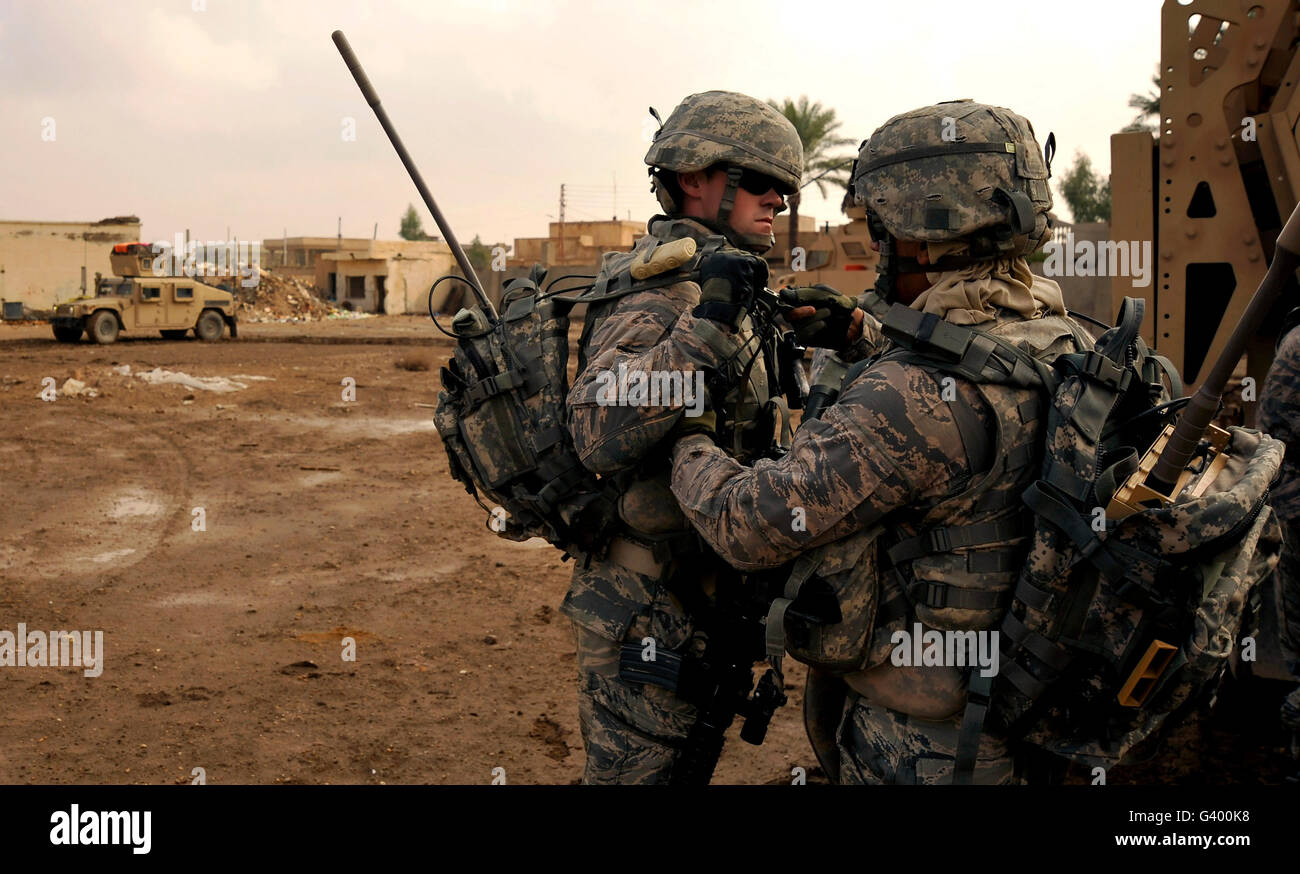 I soldati si aiutano vicendevolmente con i loro attrezzi prima di un piede di pattugliamento a Baghdad, Iraq. Foto Stock