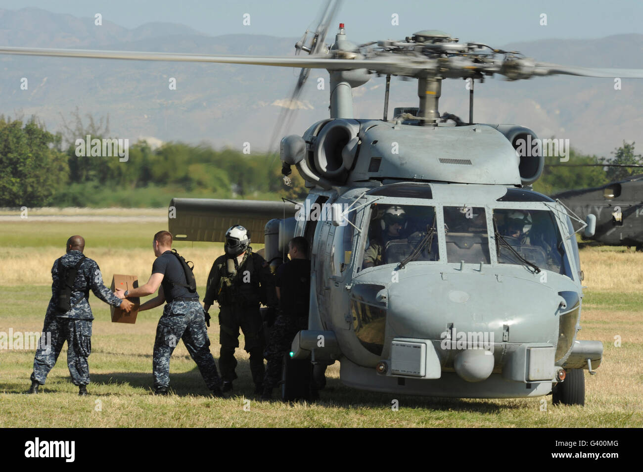 Stati Uniti I marinai della marina militare carico di rifornimenti umanitari su una marina HH-60 Pave Hawk elicottero. Foto Stock