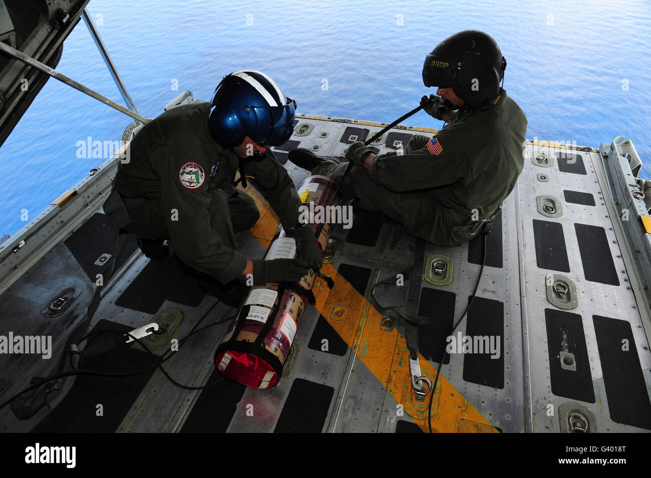 Sottufficiali prepararsi a goccia un satellite-dati attivati boa segnaletica dalla parte posteriore di una C-130 Hercules. Foto Stock