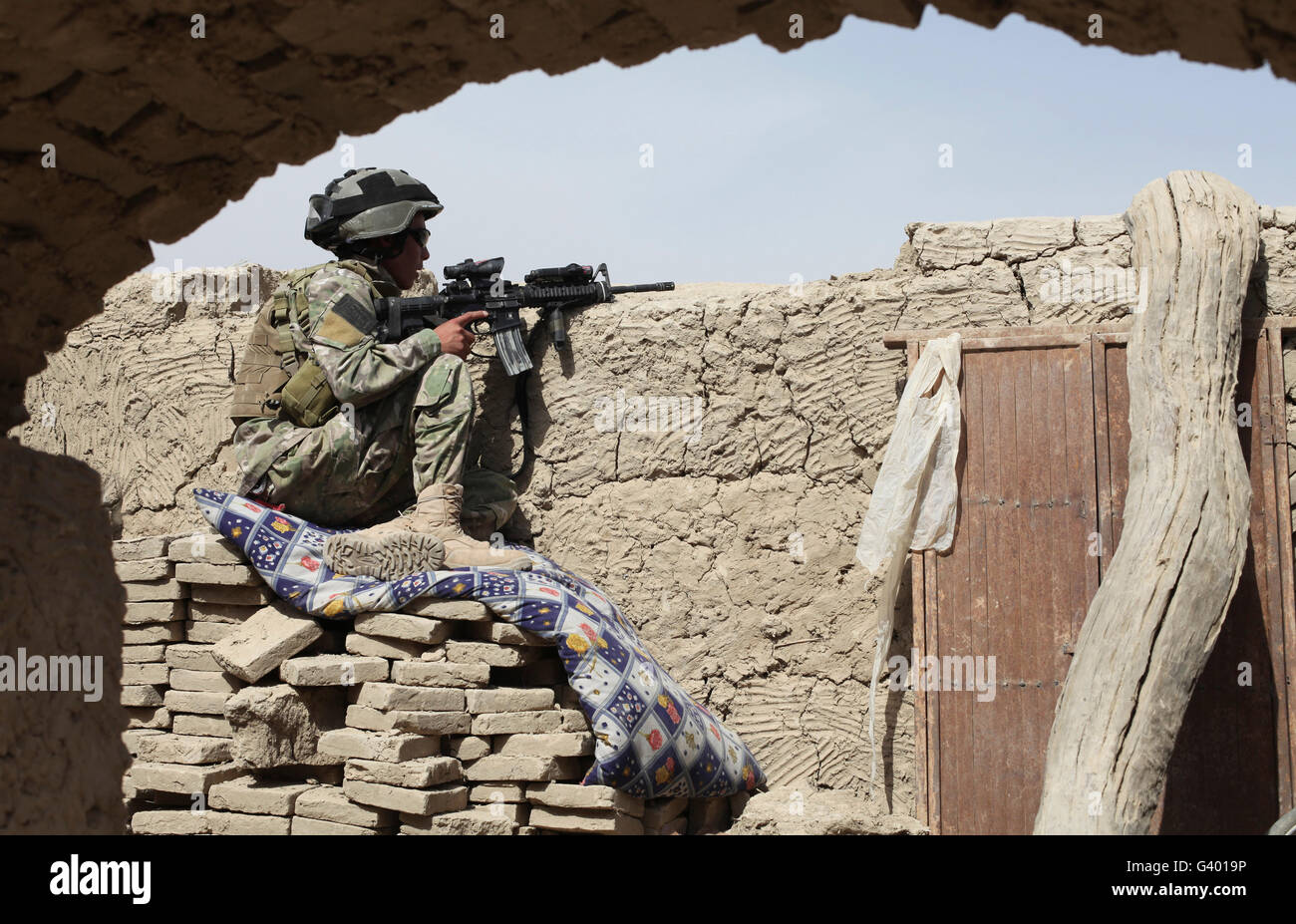 Un membro di una forza internazionale di sicurezza protegge l'area nel quartiere di Kandahar in Afghanistan. Foto Stock