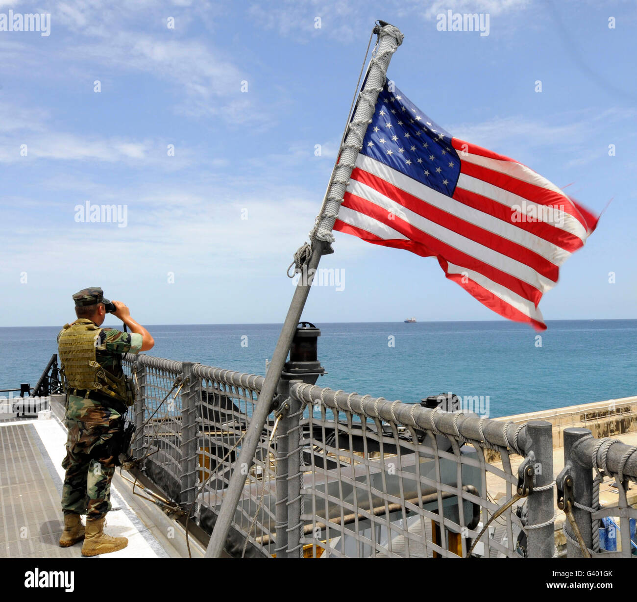 Stati Uniti Navy Seaman sorge guarda sul ponte in elicottero a bordo ad alta velocità a nave Swift. Foto Stock