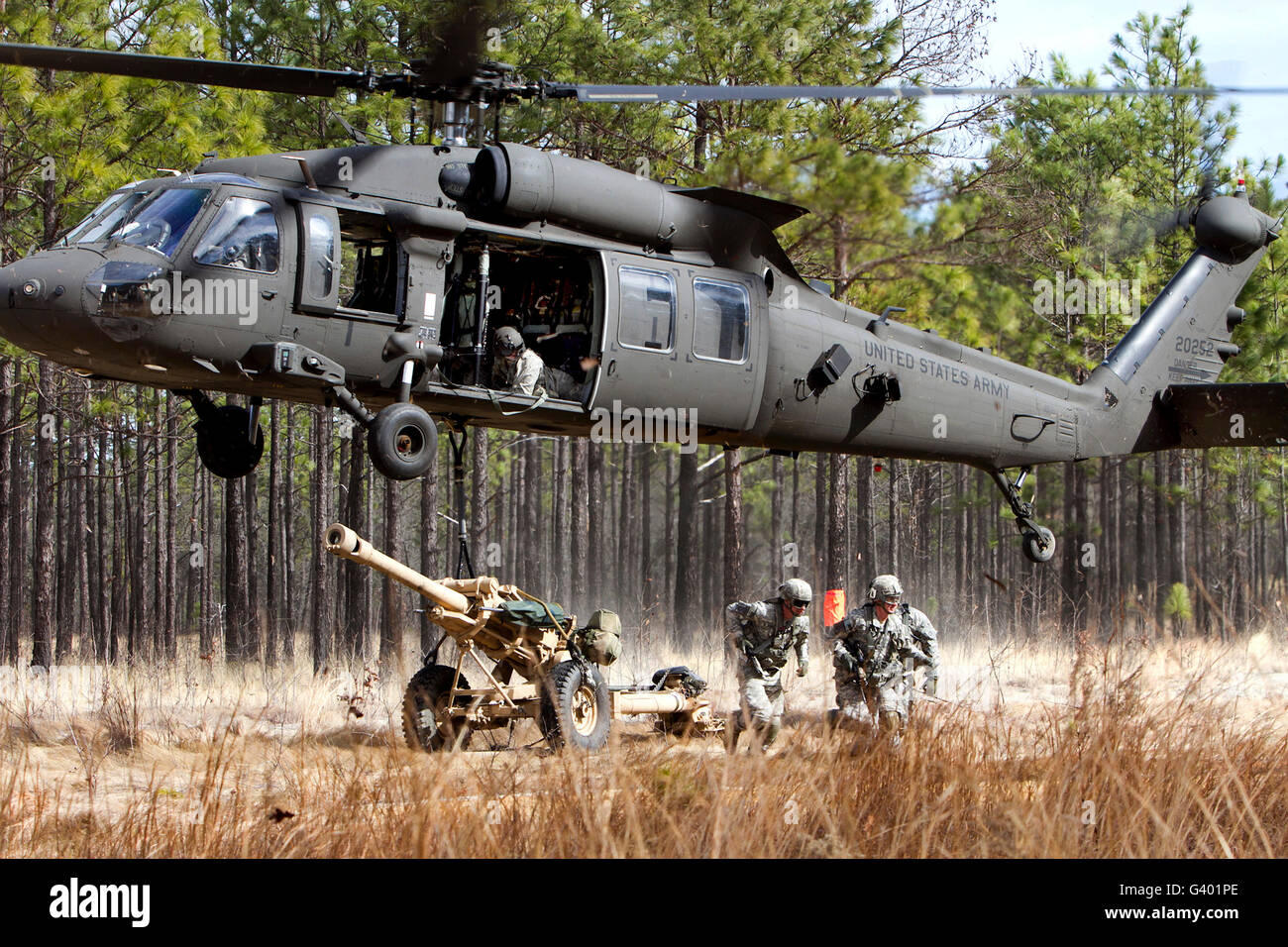 Paracadutisti collegare un obice a UH-60M Black Hawk elicottero. Foto Stock