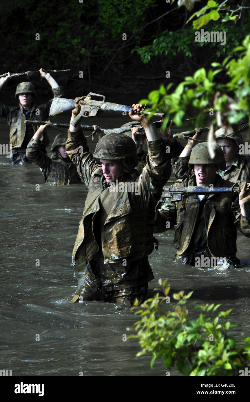 Aspiranti guardiamarina attraversare un torrente durante le prove in mare. Foto Stock