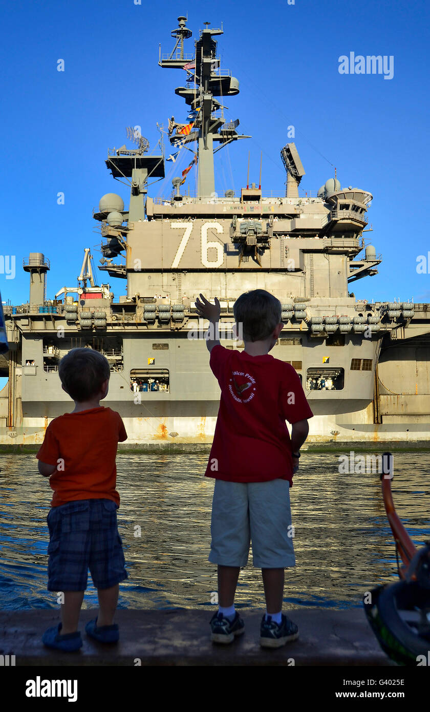 I bambini come onda USS Ronald Reagan ritorna per una porta programmata visita. Foto Stock