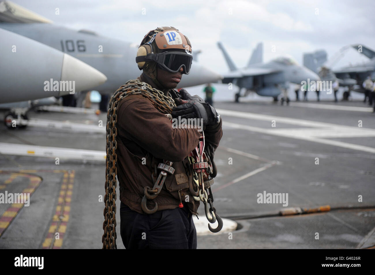Airman stand by con fascetta di fissaggio catene prima di operazioni di volo. Foto Stock