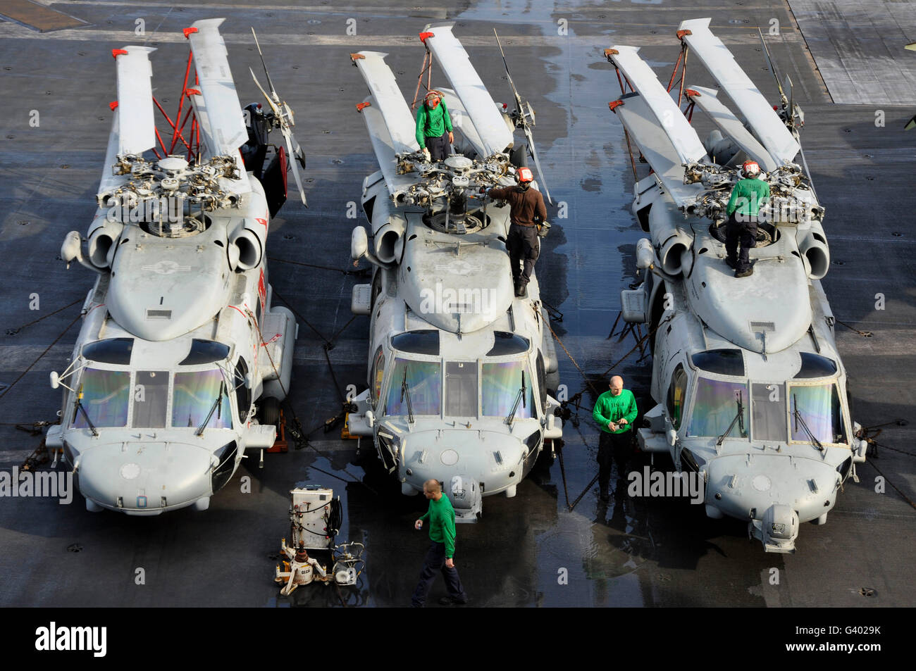 I marinai di eseguire le operazioni di manutenzione su MH-60S Sea Hawk elicotteri. Foto Stock