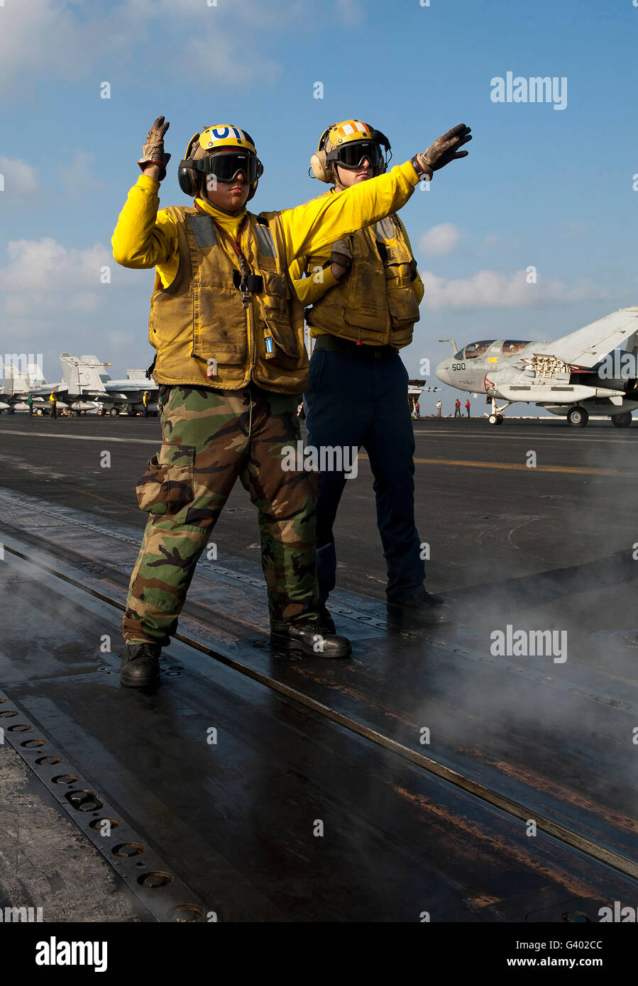 Avieri dirigere un'F/A-18C Hornet sul ponte di volo della USS John C. Stennis. Foto Stock