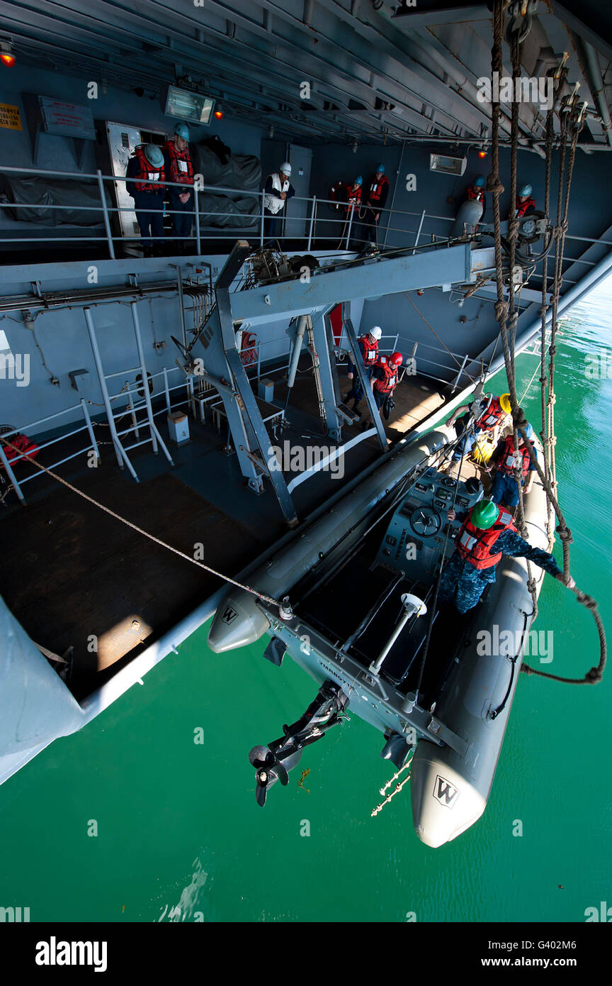 I membri dell'equipaggio immettere la dritta rigida-scafo gommone. Foto Stock