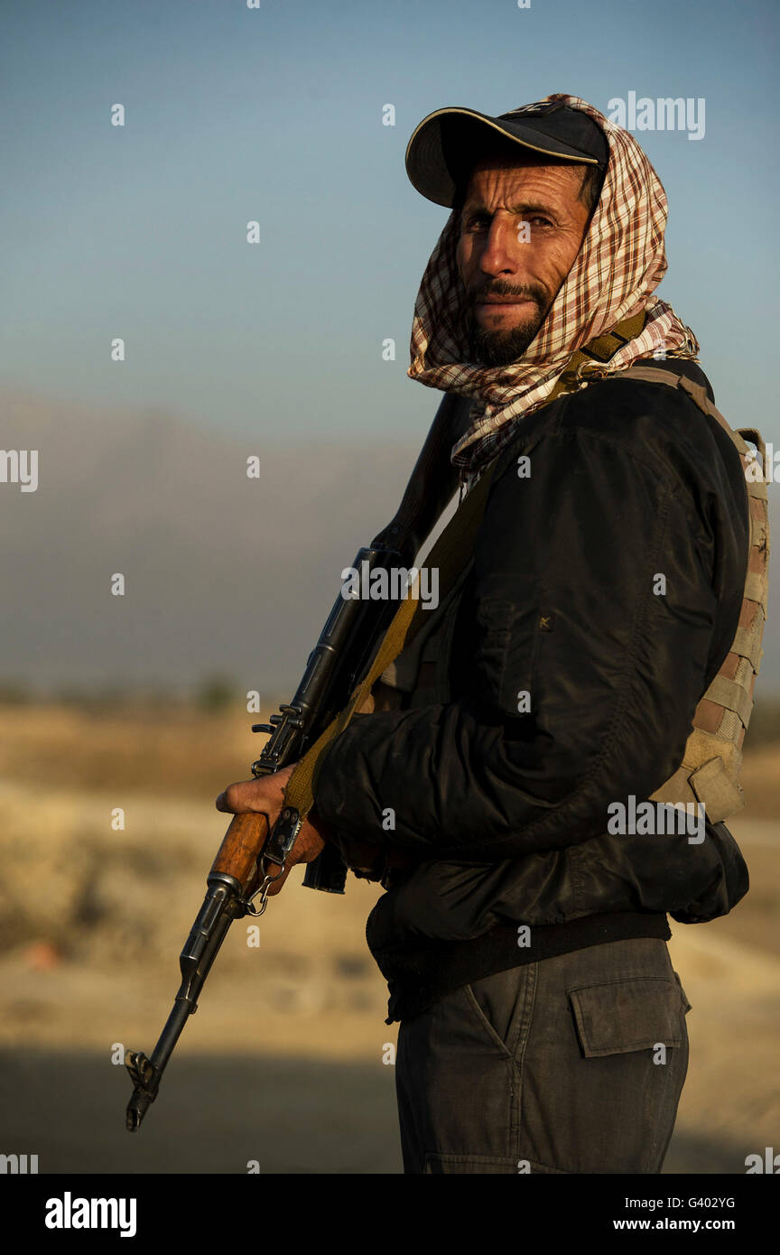 Un Afghan security guard sta guarda ad un checkpoint in Afghanistan. Foto Stock