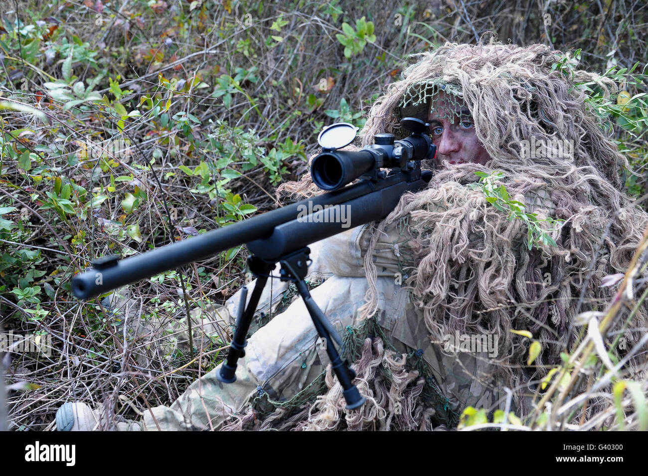 Sniper vestito in una ghillie suit. Foto Stock