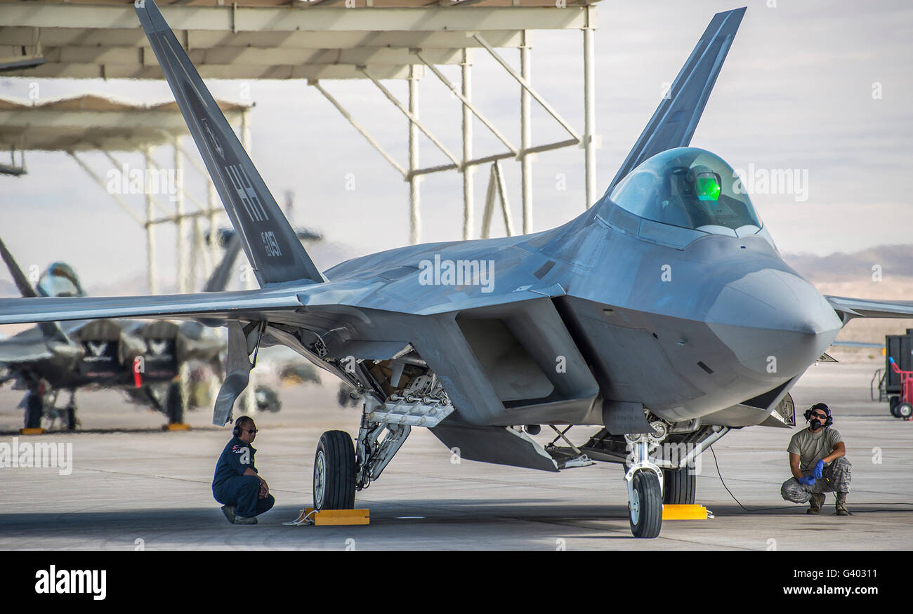 Manutentori di aeromobili condotta pre-volo checkson un F-22 Raptor. Foto Stock