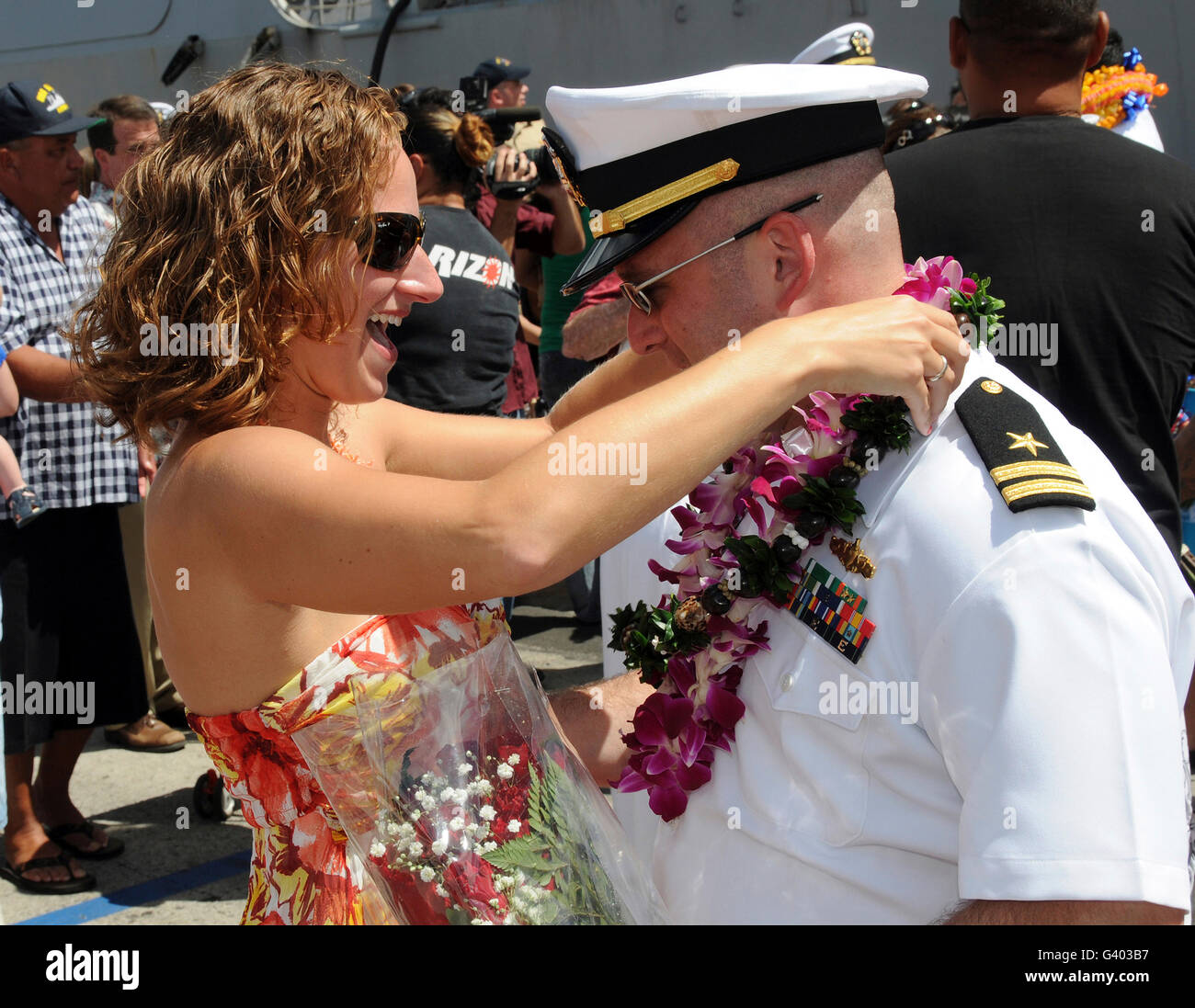 Un U.S. Navy sailor abbraccia la moglie pierside alla stazione navale Pearl Harbor. Foto Stock