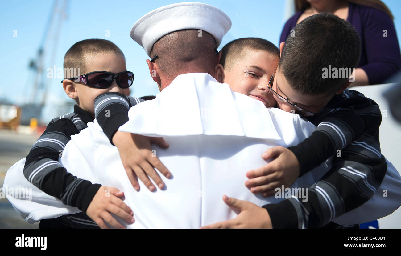 Stati Uniti Navy sailor abbraccia i suoi figli durante una celebrazione homecoming. Foto Stock