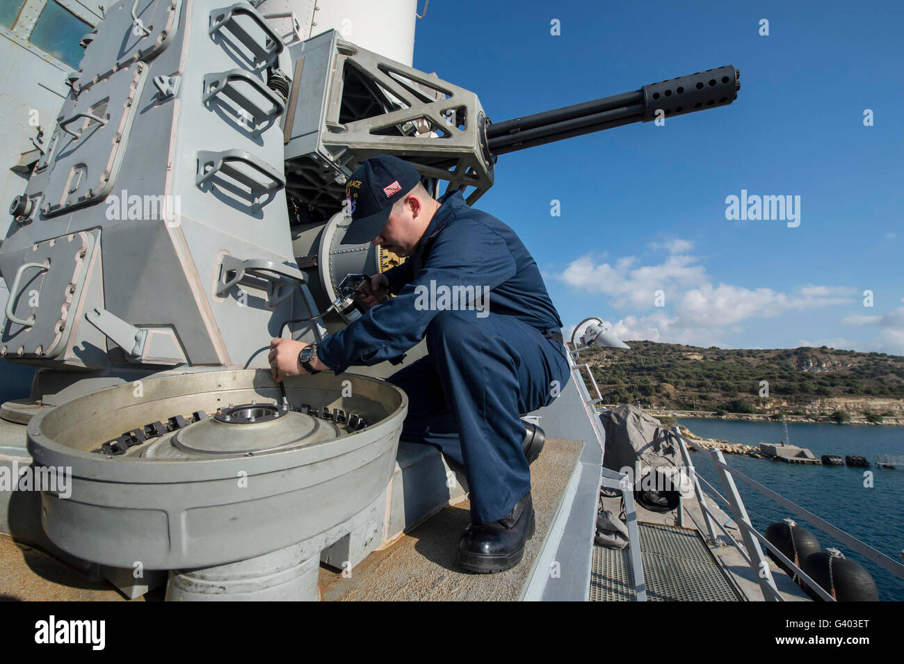 Fire Controlman grassi un tamburo di munizioni su un vicino-in sistema seapons. Foto Stock