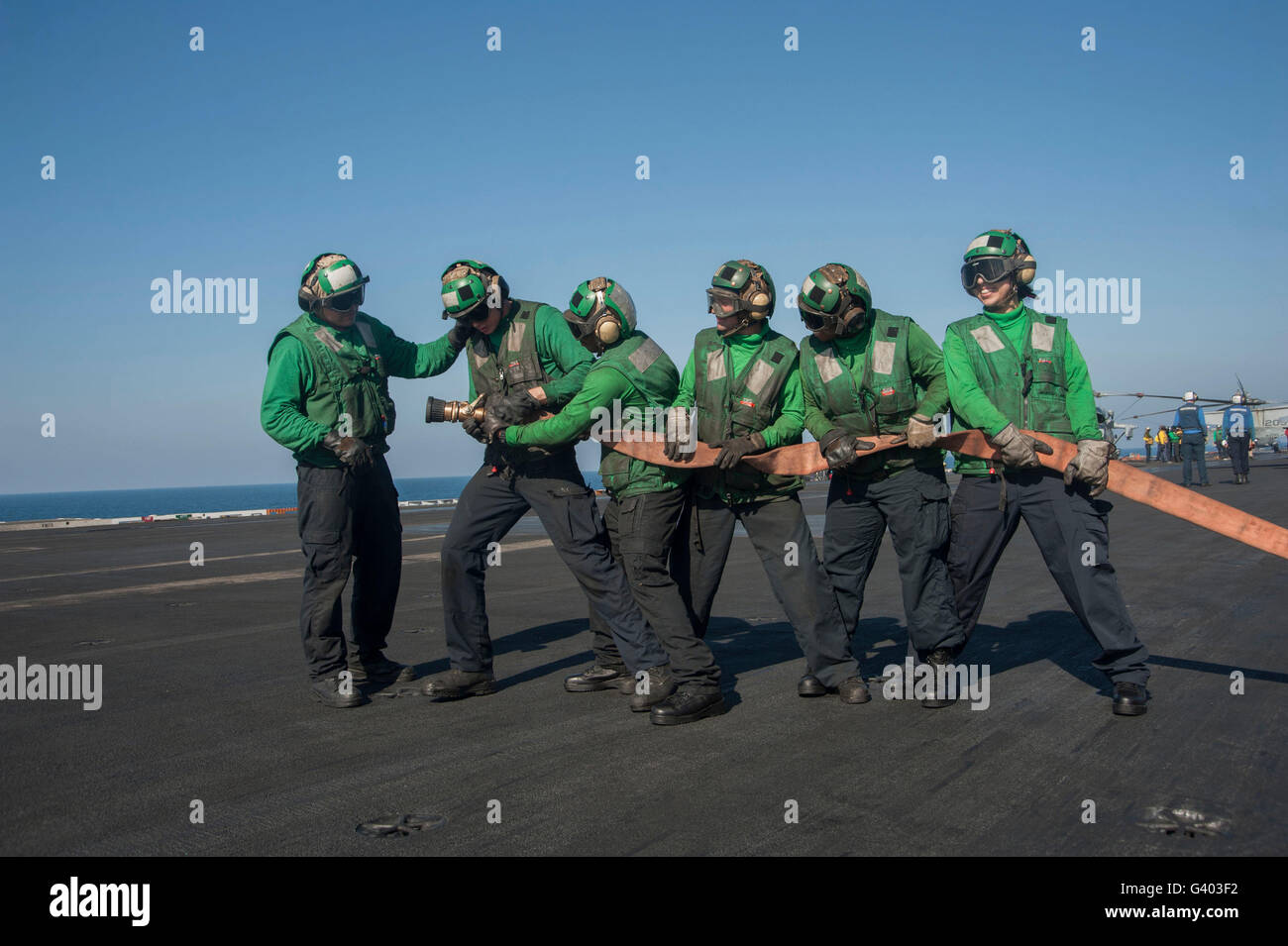 I marinai la lotta contro un incendio simulato sul ponte di volo della USS Harry Truman. Foto Stock