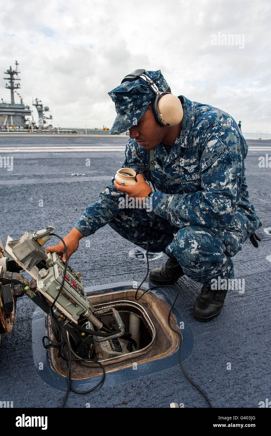 Airman opera uno stadio superiore elevatore sul pannello di controllo a bordo della USS Harry Truman. Foto Stock