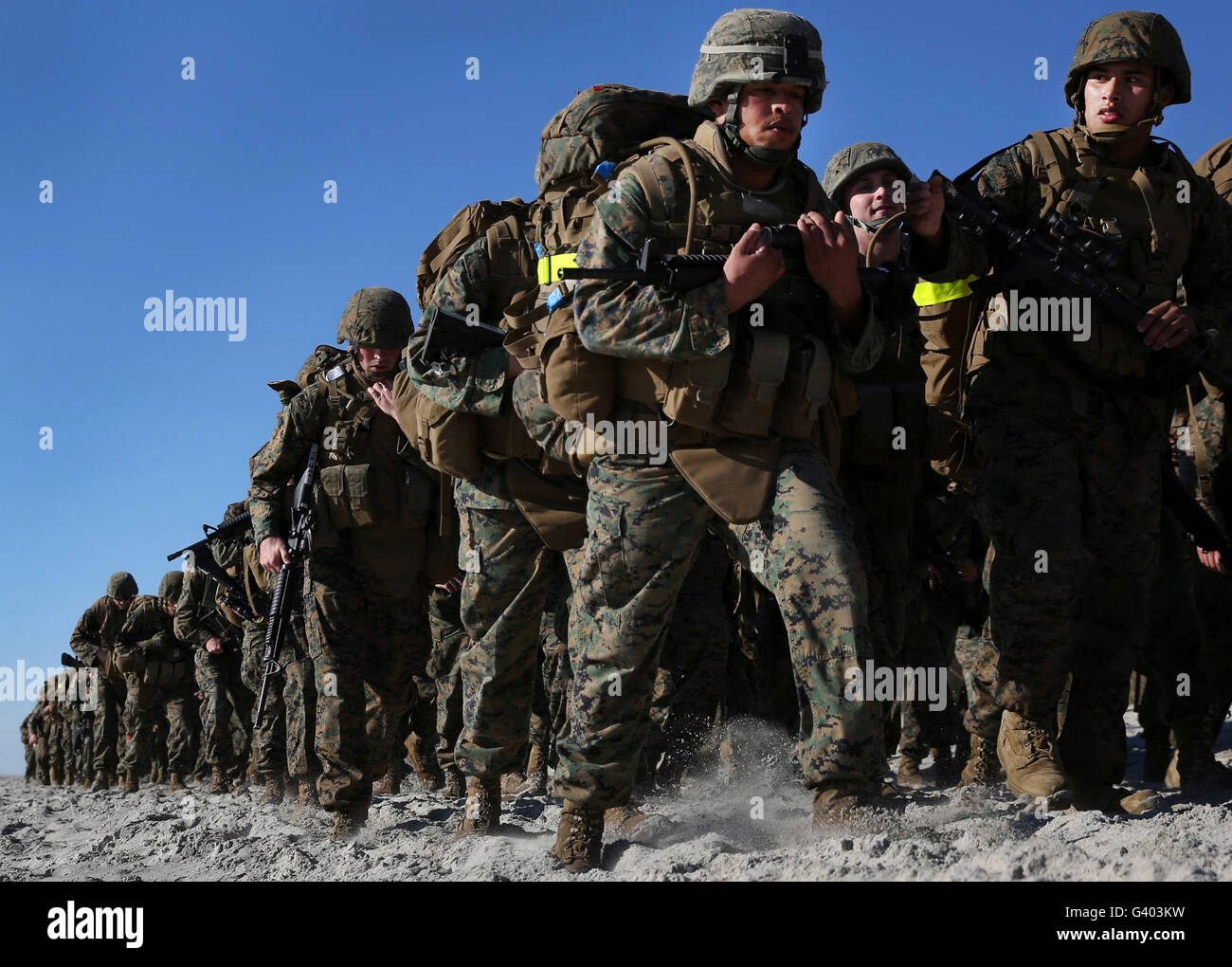 Marines e marinai tramp attraverso le sabbie della spiaggia di Onslow. Foto Stock