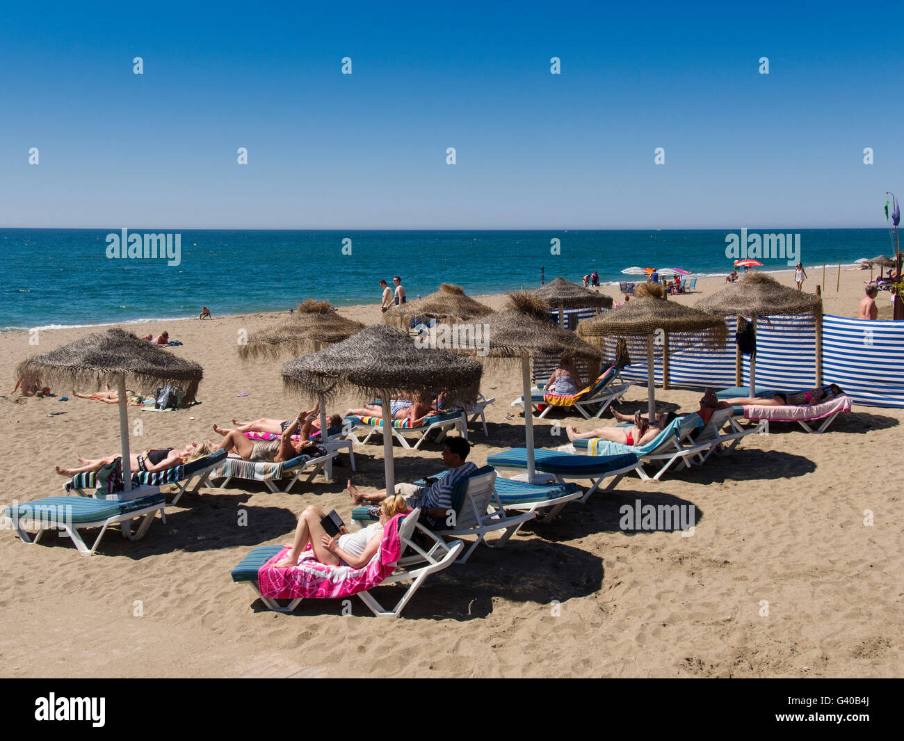 I turisti sulla spiaggia. Mijas Costa, provincia di Malaga, Costa del Sol, Mediterranea mare, Andalusia, Spagna Europa Foto Stock