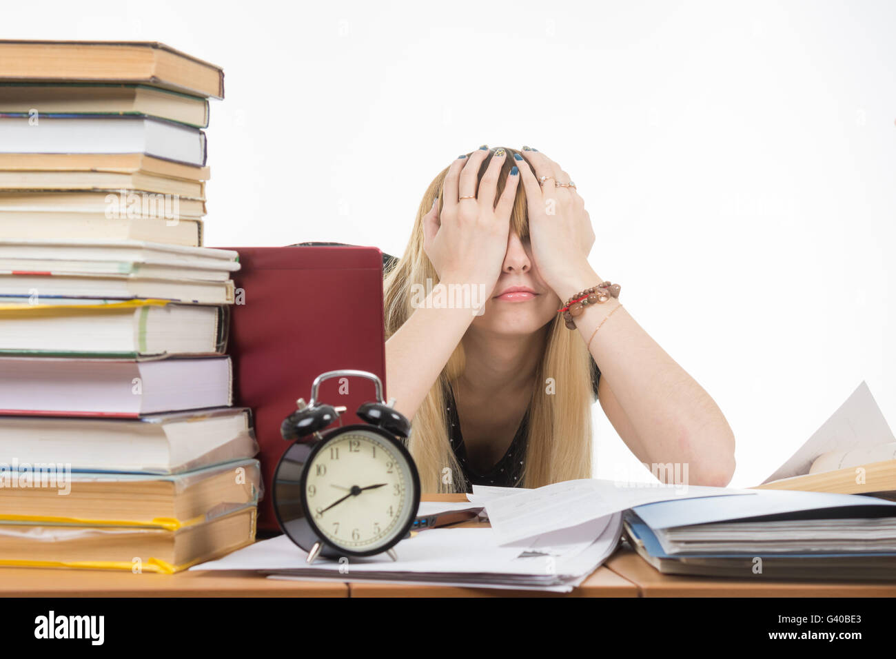 Lo studente che copre la sua gli occhi con le mani a prendere una pausa dai loro studi Foto Stock