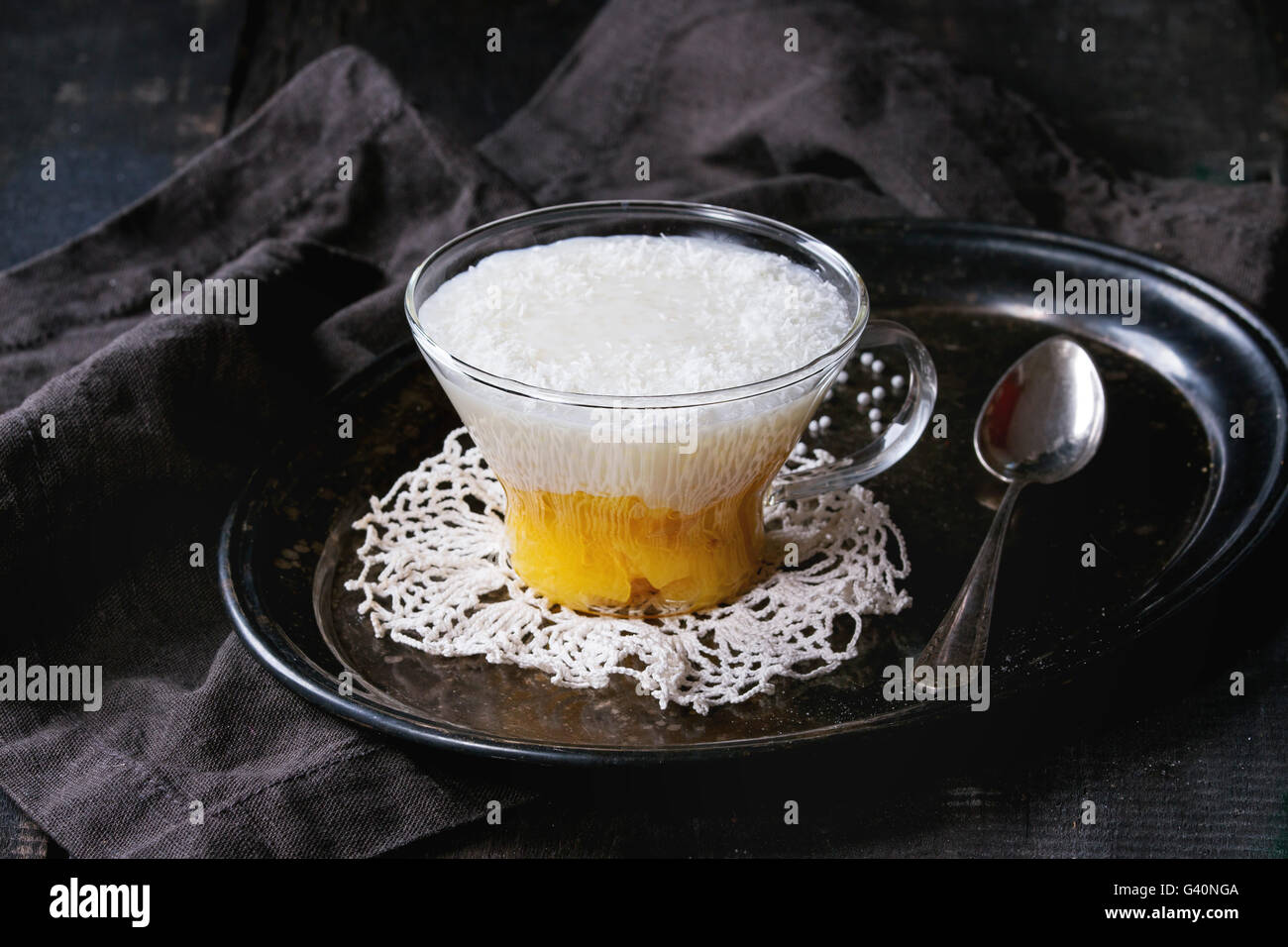 Sana le perle di tapioca pudding dessert con latte di cocco e mango. Servito in vetro su vintage vassoio di ferro su un vecchio tavolo in legno w Foto Stock