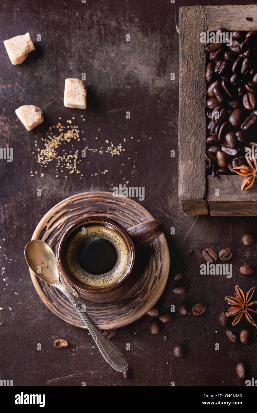 Verde e marrone e non torrefatto Caffè decaffeinato e nero caffè torrefatto in grani con spezie e zucchero nella vecchia scatola di legno e la tazza di ceramica di fresco Foto Stock