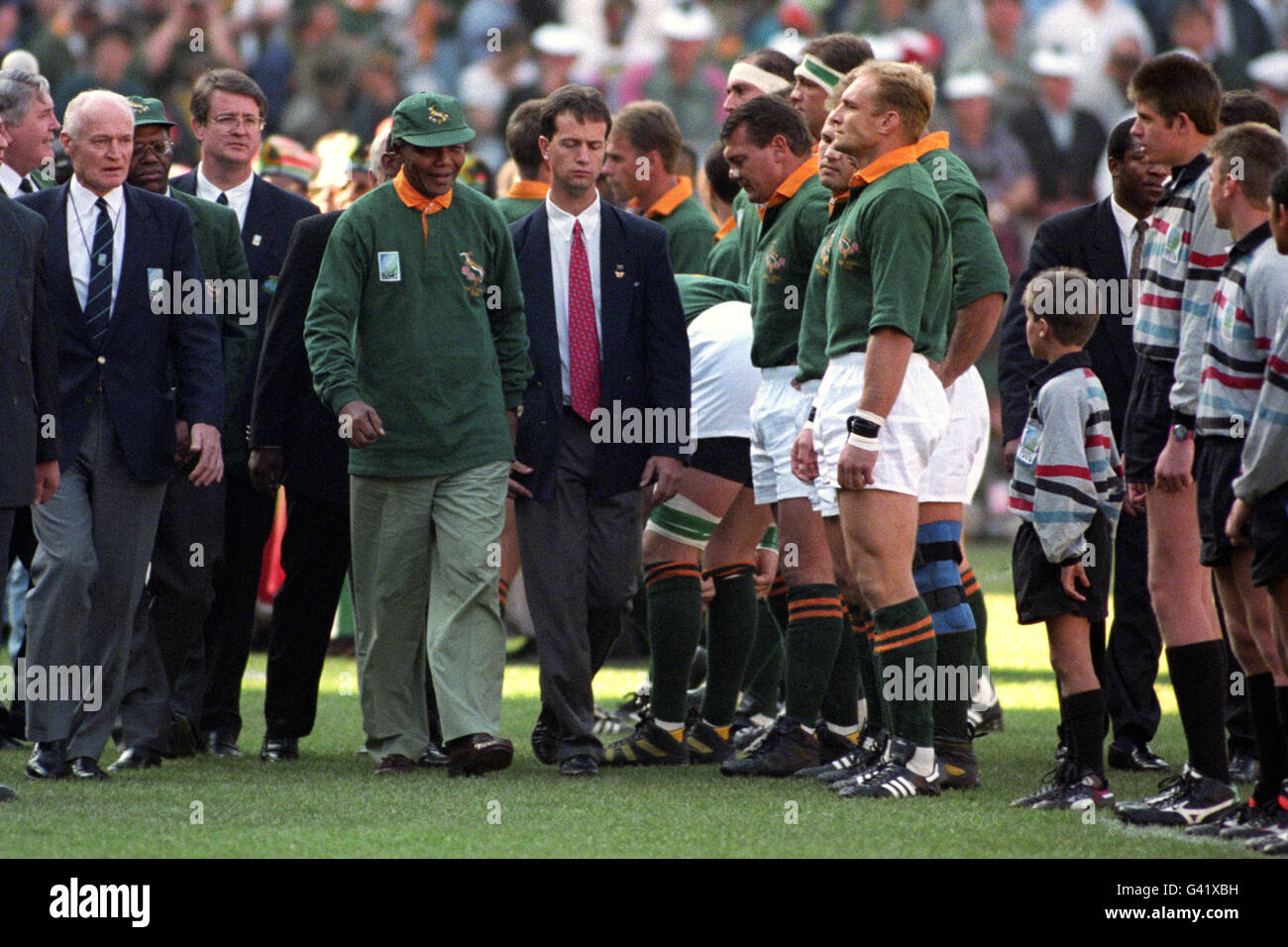 Nelson Mandela passa accanto a Francois Pienaar in fila prima della finale  della Coppa del mondo di Rugby nell'Ellis Park di Johannesburg.  Sull'estrema sinistra si trova Sir Ewart Bell Presidente della Coppa