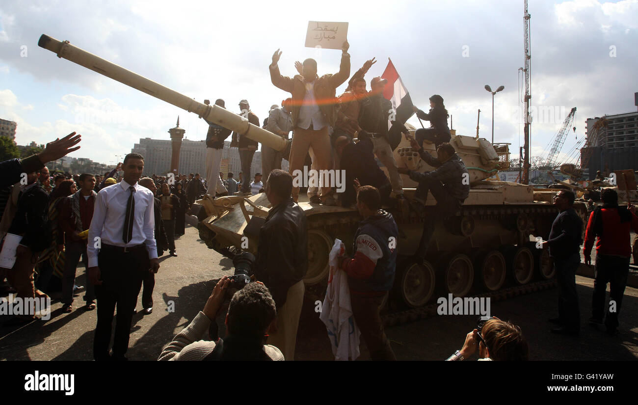 I manifestanti salgono su un carro armato vicino a Piazza Tahrir al Cairo, in Egitto, mentre continuano le proteste di massa contro il dominio decennale del presidente Hosni Mubarak in tutto il paese. Foto Stock