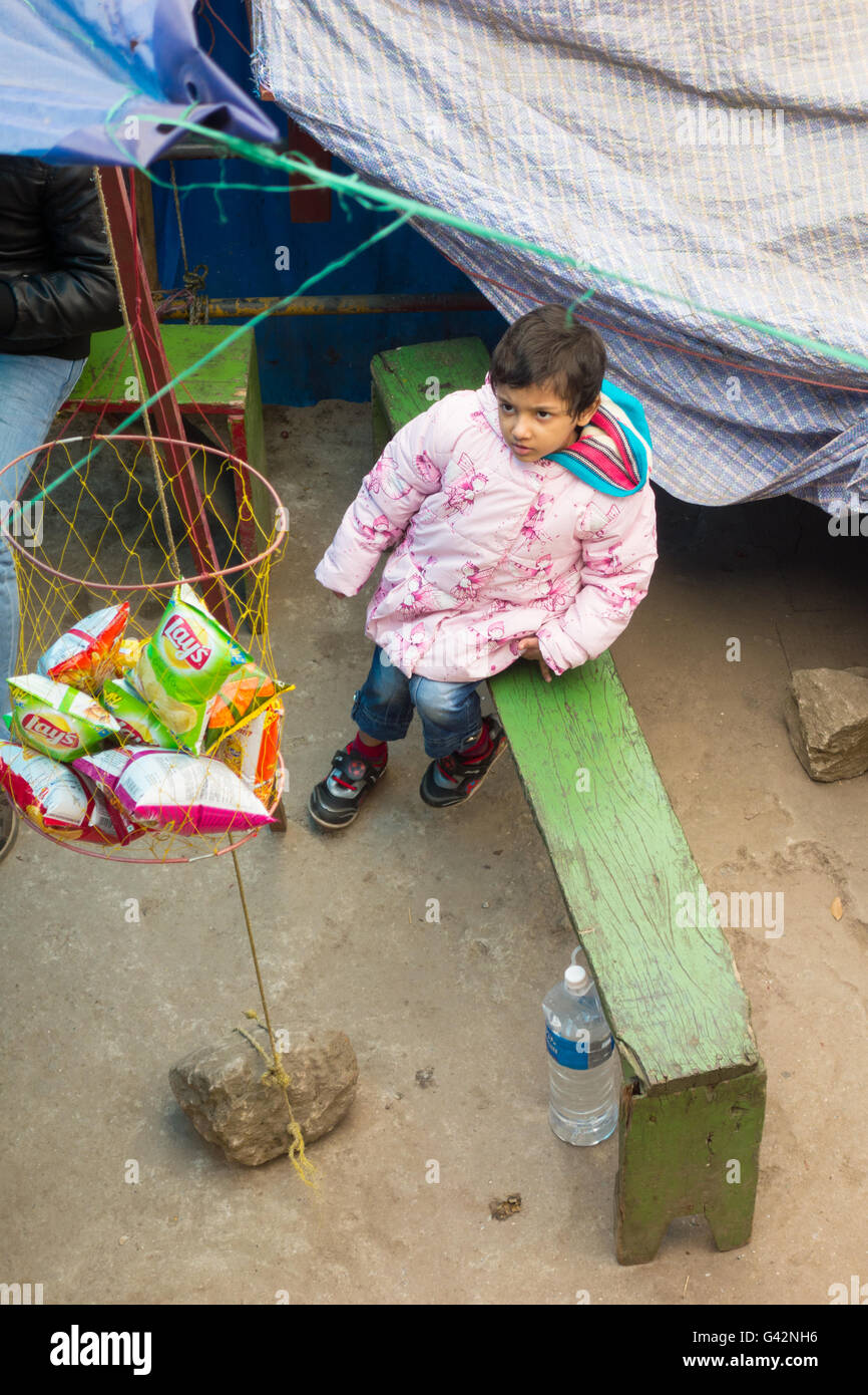 Grazioso piccolo ragazza indiana bambino guardando il Lay's potato chips pacchetti in Darjeeling, West Bengal, India Foto Stock