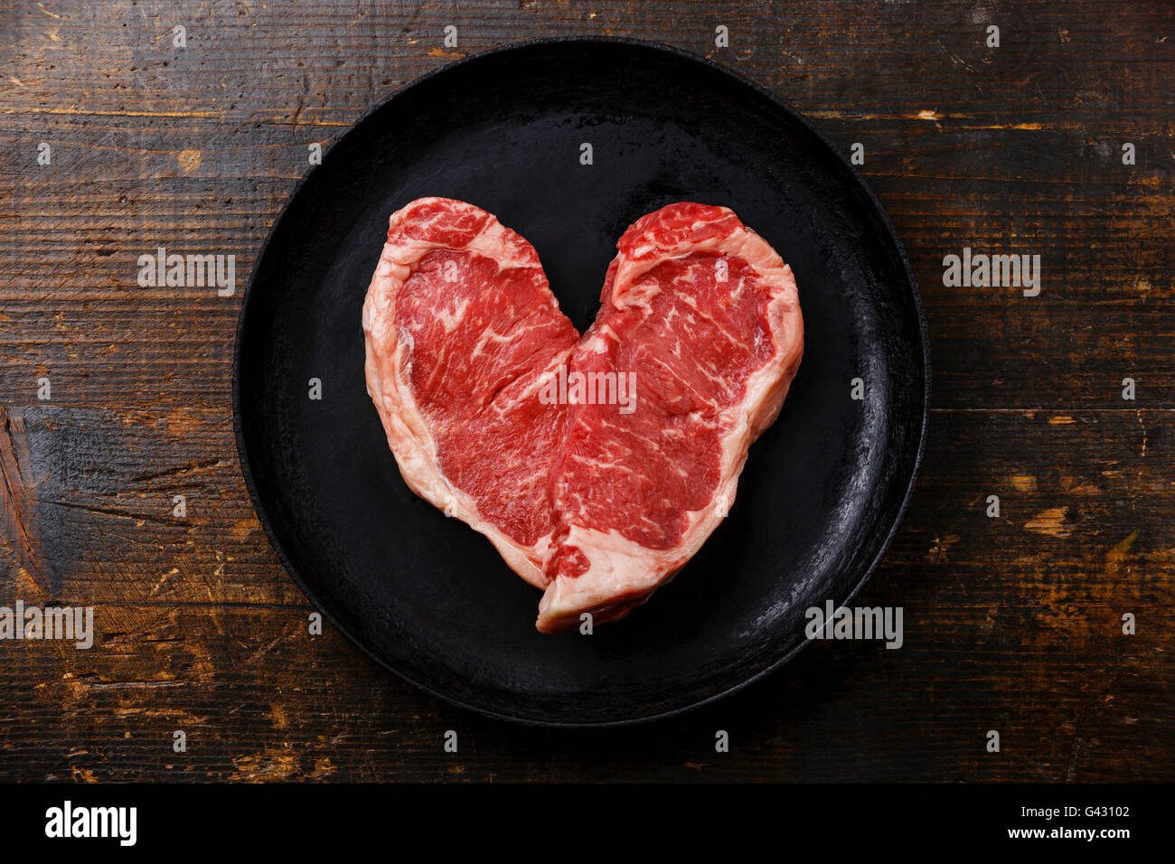 Forma di cuore crudo fresco bistecca di carne controfiletto per due in padella Foto Stock