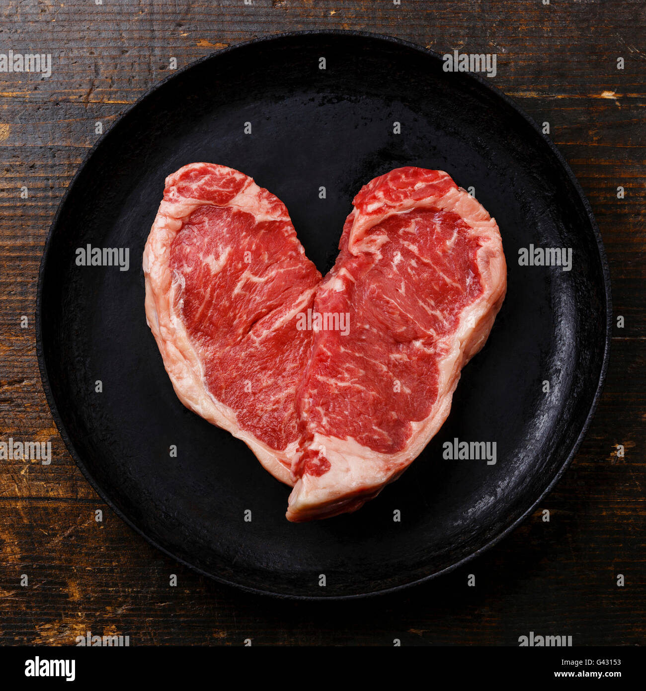 Forma di cuore crudo fresco bistecca di carne controfiletto per due in padella Foto Stock
