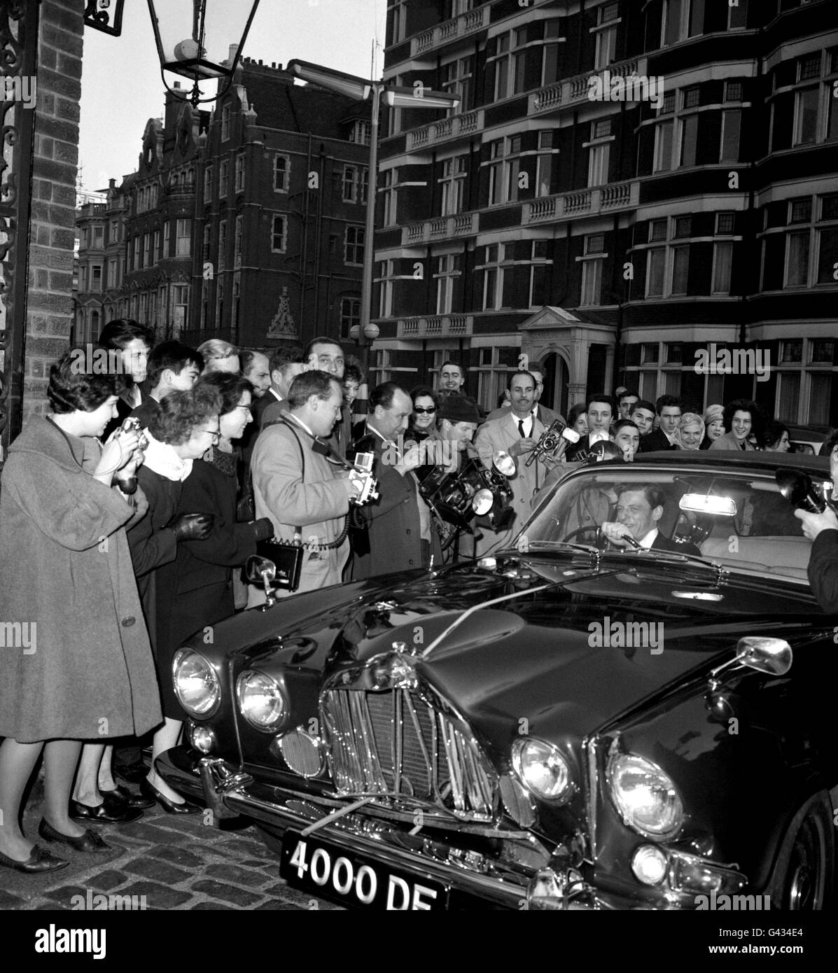 Angus Ogilvy, guidando una jaguar con una parte anteriore gravemente danneggiata, a seguito di una collisione con un viaggiatore Morris, il cui conducente è stato citato come "non farò mai riparare il danno". Ogilvy arrivò a Kensington Palace, Londra, prima di partire con la sua fidanzata principessa Alexandra di Kent, per un pallone dato dalla Regina al Castello di Windsor. Foto Stock