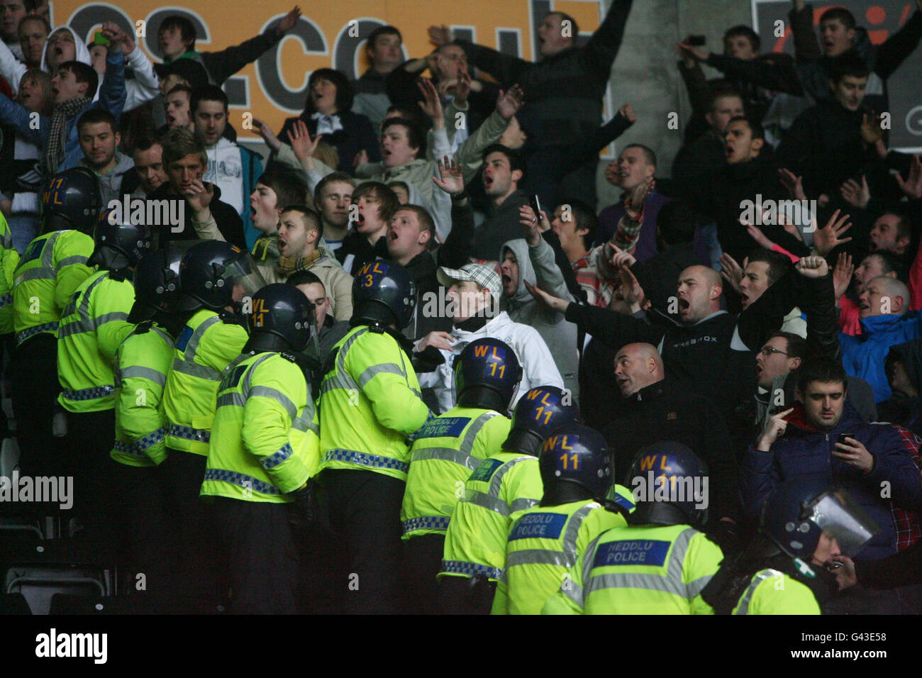 I fan di Swansea City gridano ai fan della città di Cardiff mentre la polizia li tiene separati durante la partita del campionato Npower al Liberty Stadium di Swansea. Foto Stock