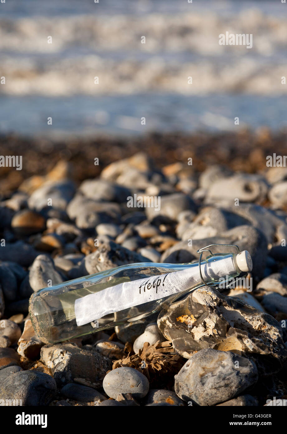 Un messaggio in bottiglia su una spiaggia ghiaiosa Foto Stock