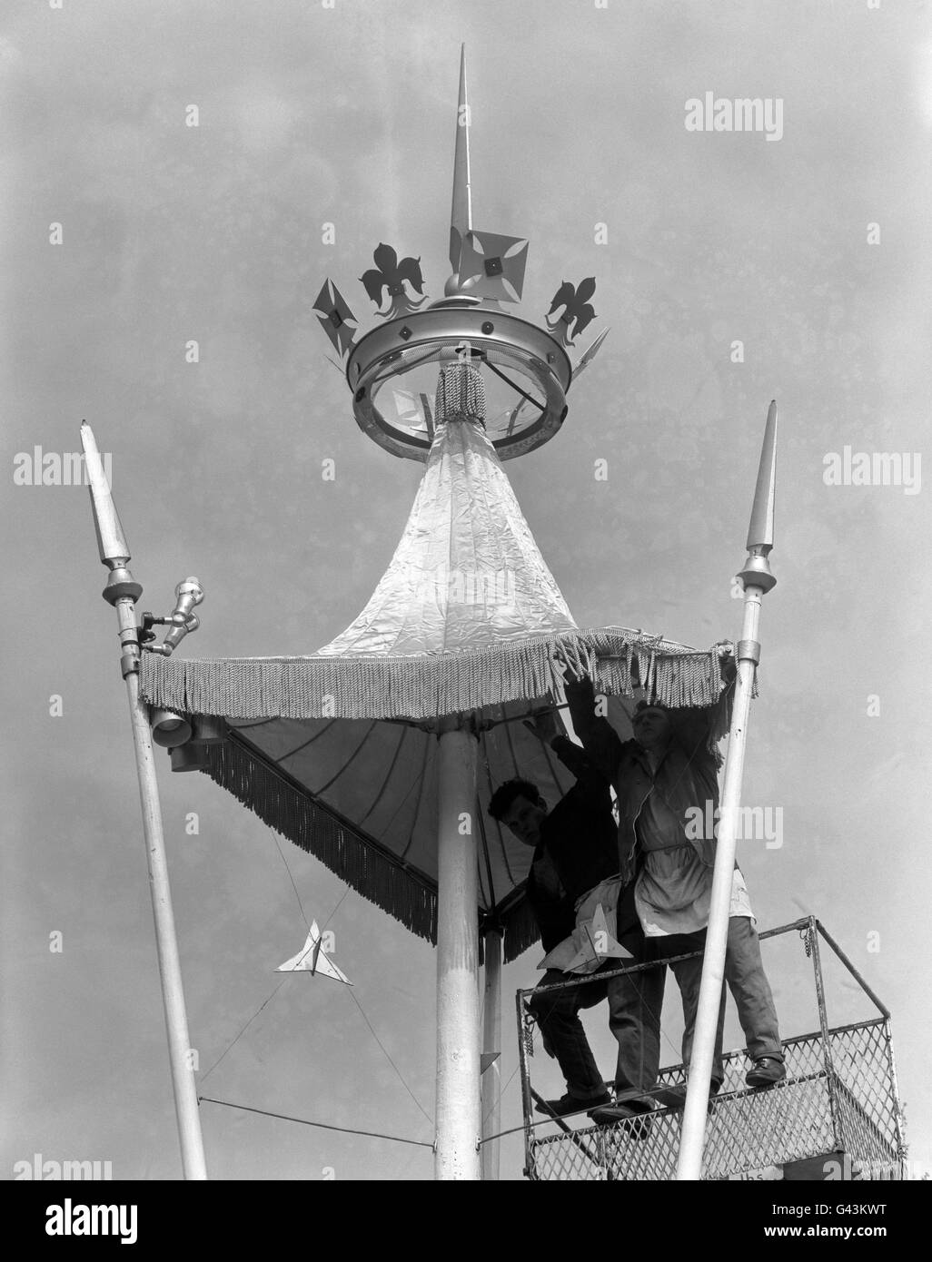 Operai in piedi su una piattaforma idraulica, posizionando una tenda sotto una corona dorata, sulla via processionale per le nozze della principessa Margaret e di Antony Armstrong-Jones. Foto Stock
