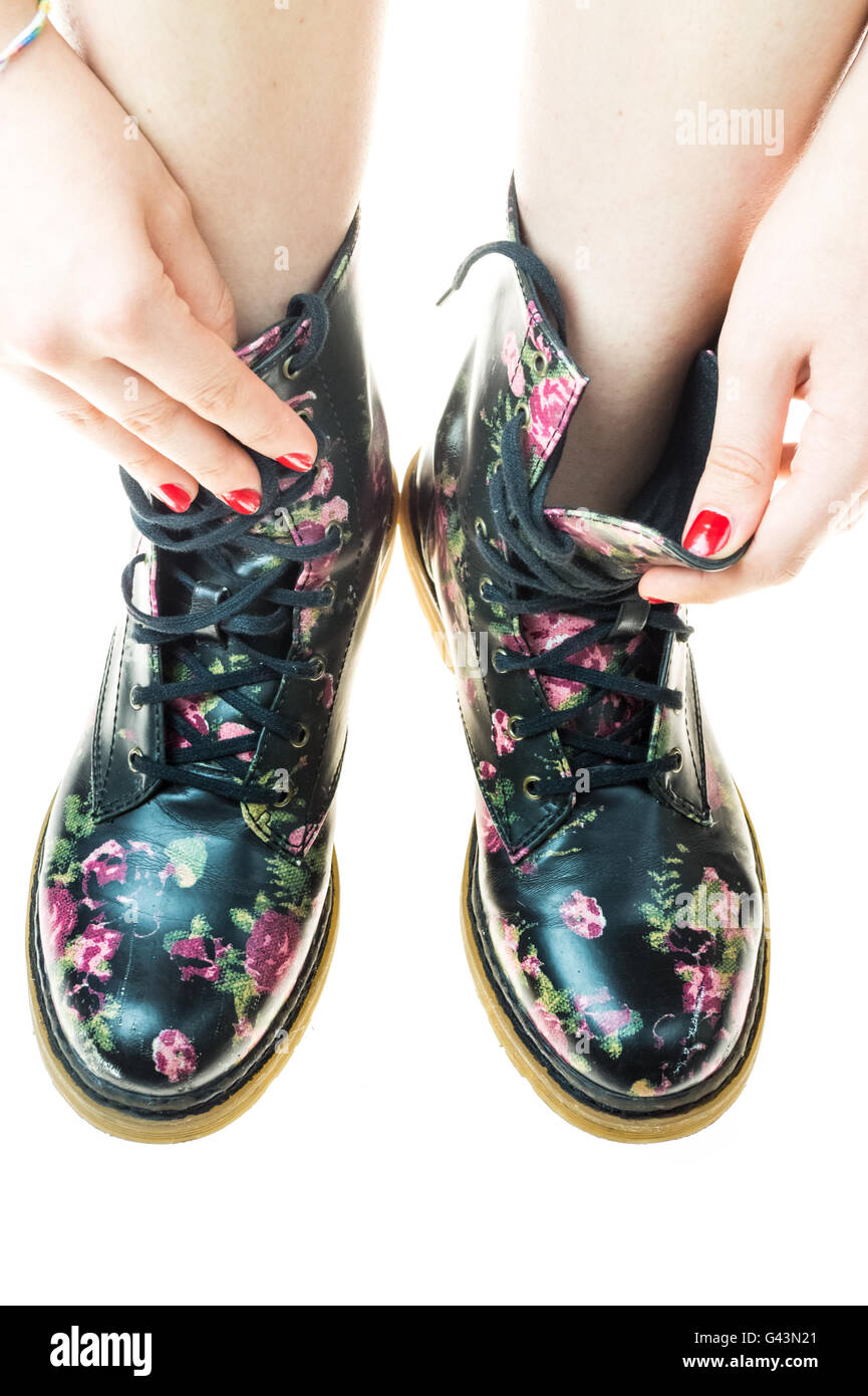 Stile militare stivali con fiori di decorazione su un mani con polis chiodi rossi Foto Stock