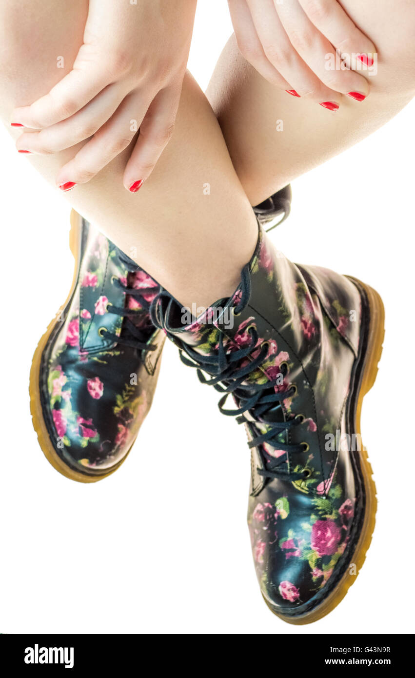 Stile militare stivali con fiori di decorazione su un mani con polis chiodi rossi Foto Stock