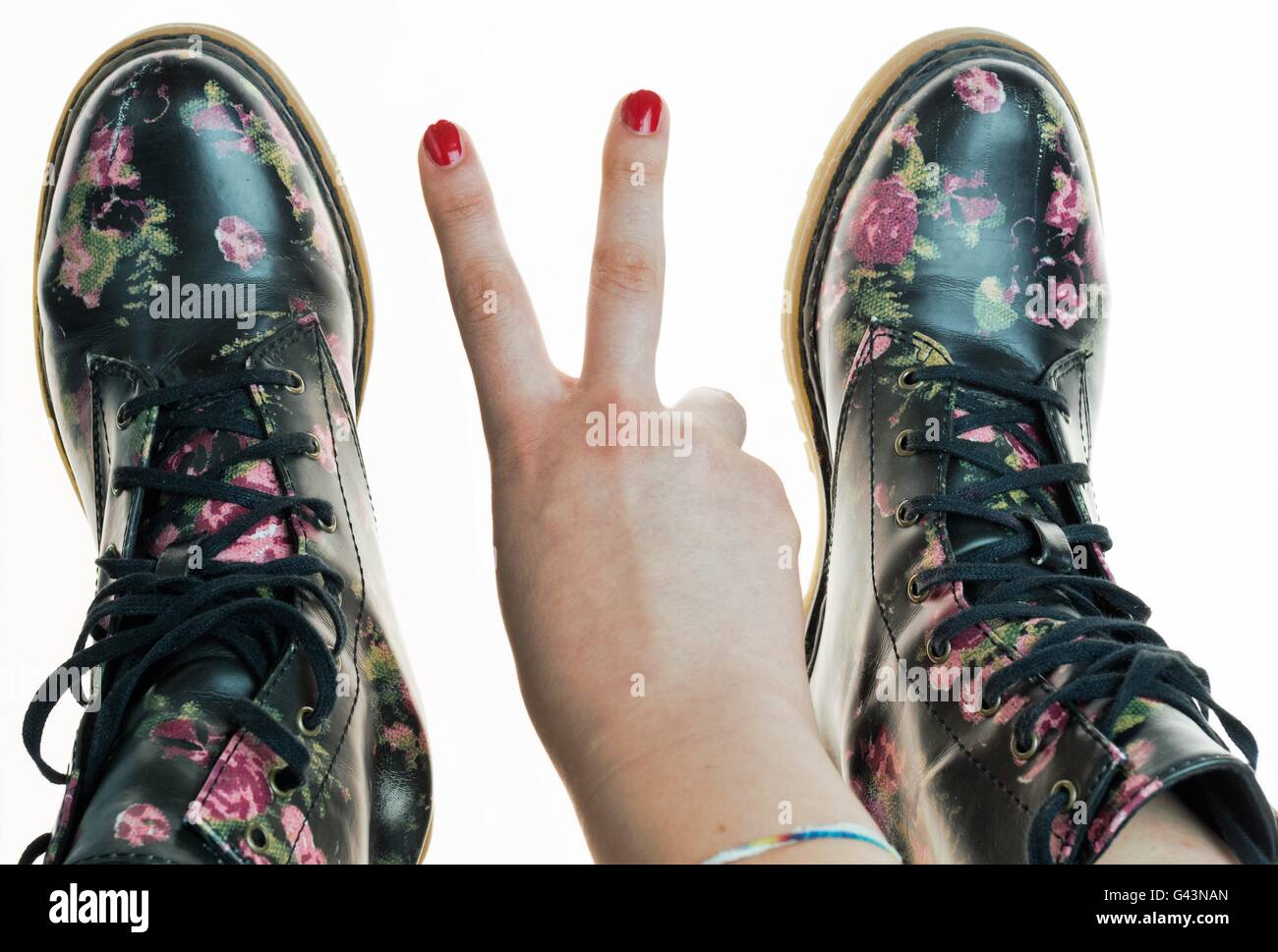 Stile militare stivali con fiori di decorazione su un mani con polis chiodi rossi Foto Stock