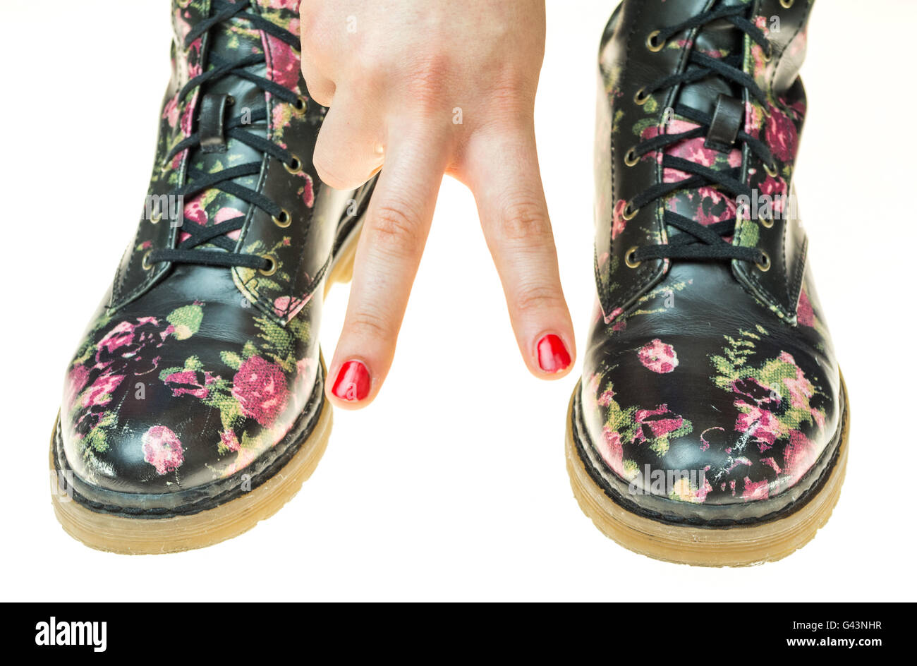 Stile militare stivali con fiori di decorazione su un mani con polis chiodi rossi Foto Stock