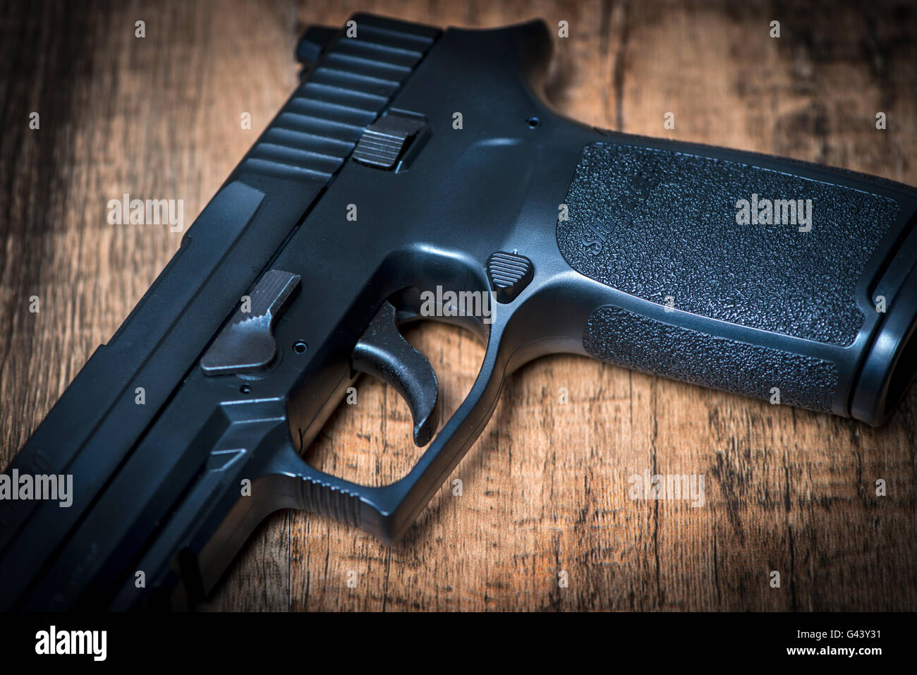Un Sig P250 pistola semi-automatica su una superficie di legno Foto Stock