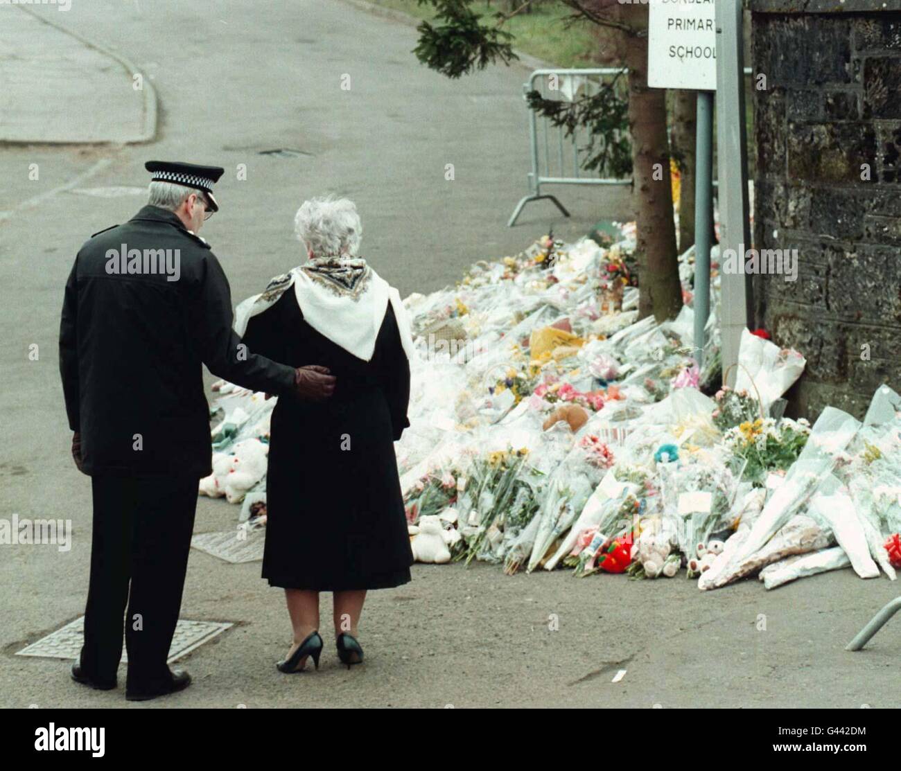 Una signora è confortata da un poliziotto fuori della scuola primaria di Dunblane questa mattina (sabato), la mattina dopo una veglia alla cattedrale della città è stato assistito da migliaia di persone che si lamentano per la morte dell'insegnante e degli scolari. Foto Stock